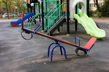 Plastic child playground after rain. Russian swing for children. Colorful attractions for children