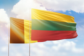 Sunny blue sky and flags of lithuania and belgium