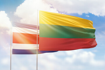 Sunny blue sky and flags of lithuania and costa rica