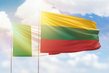 Sunny blue sky and flags of lithuania and italy