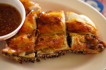 Grilled chicken with dipping sauce on a plate