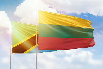 Sunny blue sky and flags of lithuania and tanzania