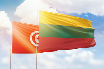 Sunny blue sky and flags of lithuania and tunisia
