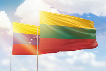 Sunny blue sky and flags of lithuania and venezuela