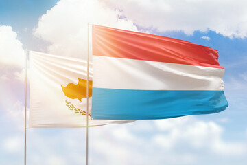 Sunny blue sky and flags of luxembourg and cyprus