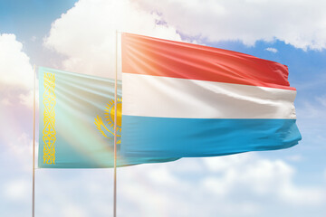 Sunny blue sky and flags of luxembourg and kazakhstan