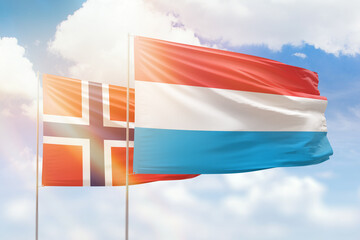 Sunny blue sky and flags of luxembourg and norway