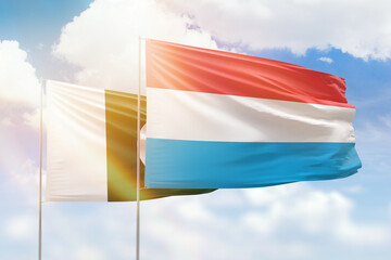 Sunny blue sky and flags of luxembourg and pakistan