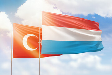 Sunny blue sky and flags of luxembourg and turkey