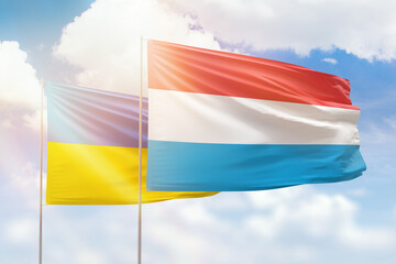 Sunny blue sky and flags of luxembourg and ukraine