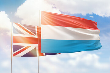 Sunny blue sky and flags of luxembourg and united kingdom