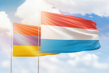 Sunny blue sky and flags of luxembourg and armenia