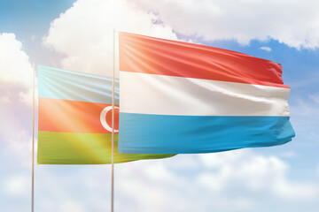 Sunny blue sky and flags of luxembourg and azerbaijan