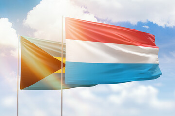 Sunny blue sky and flags of luxembourg and bahamas