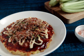 Okonomiyaki in the skillet on the table