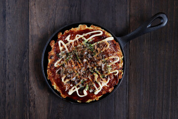 Okonomiyaki in the skillet on the table