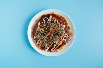 Okonomiyaki in the skillet on the table