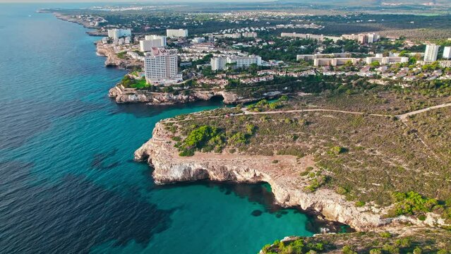 Modern build residence building with pool by the beach on rocky caves in Majorca. Carrer de Cala Antena, Cales de Mallorca, Balearic Islands, Spain.