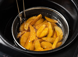 Cooking potatoes wedges in deep fryer