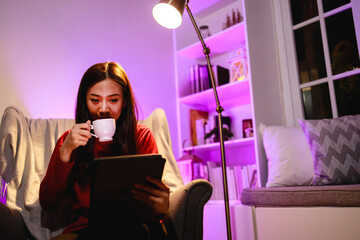 Young woman using a digital tablet at home in night time. technology, internet and people concept