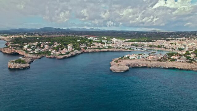 Scenic Porto Cristo Marina view from above with houses by the coast in Majorca. A view of a Spanish village known for amazing Drach Caves on the Balearic Islands, Spain.