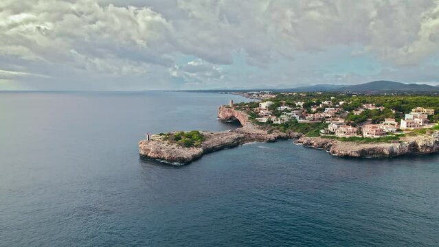 Beautiful view of coastal Porto Cristo village from above on Majorca Island. Torre del Serral dels Falcons by Drach Caves in Balearic Islands, Spain.