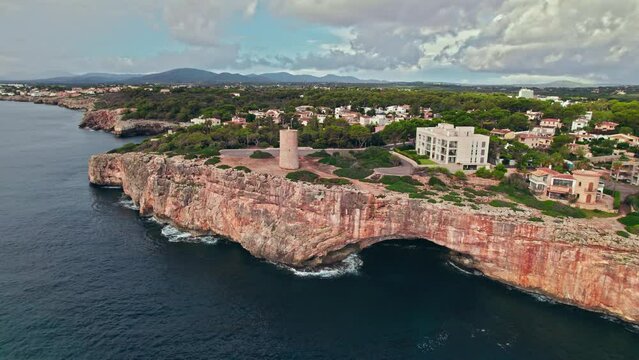 Beautiful view of coastal Porto Cristo village from above on Majorca Island. Torre del Serral dels Falcons by Drach Caves in Balearic Islands, Spain.