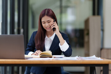 Obraz premium Image of Happy Asian Business woman discussing with her business partner by cell phone. Finance and brainstorm concept.