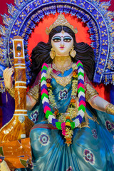 Fototapeta na wymiar Idol of Goddess Saraswati with veena, a musical instrument, at Kolkata, West Bengal, India. Saraswati is Hindu goddess of knowledge, music, art, wisdom, and learning.