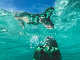Woman underwater heading swimming to the surface