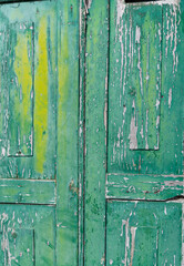 old vintage antique painted wooden doors close up green turquoise and yellow layers of paint peeling off of old doors weathered wood paint peeling vertical abstract background backdrop room for type
