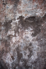 close up abstract background of cement or stone and plaster exterior wall weathered and grungy rust colored grey and white outside home wall natural abstract design vertical format 