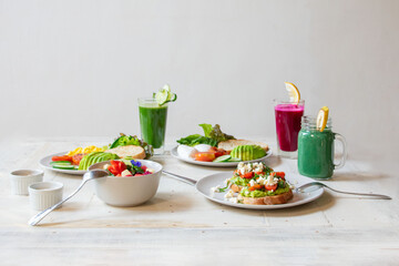 breakfast of several dishes and juices on a white background