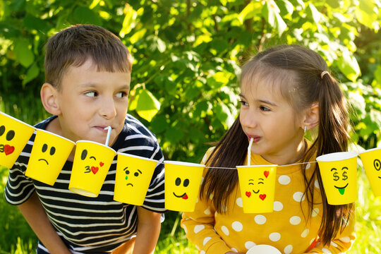 World Smile Day and Children's holiday, children have fun at a picnic in the summer, children's friendship, different emotions on paper cups
