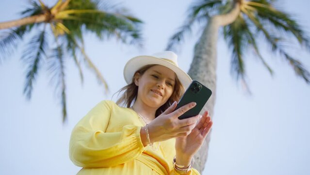 Portrait of happy tourist woman enjoy success on mobile phone at working on Hawaii island. Closeup joyful girl reading good news on phone in slow motion. Smiling lady checking inbox on phone outdoors