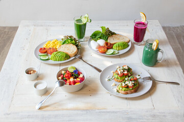 breakfast of several dishes and juices on a white background