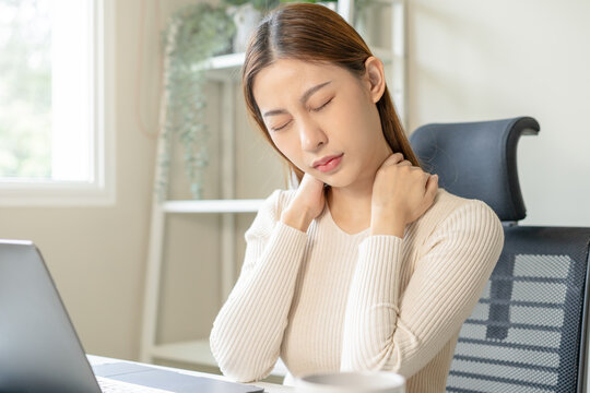 Body muscles stiff problem, ache asian young woman, girl pain neck while sitting work on chair at home, holding massaging rubbing, hurt or sore, Healthcare people, office syndrome .