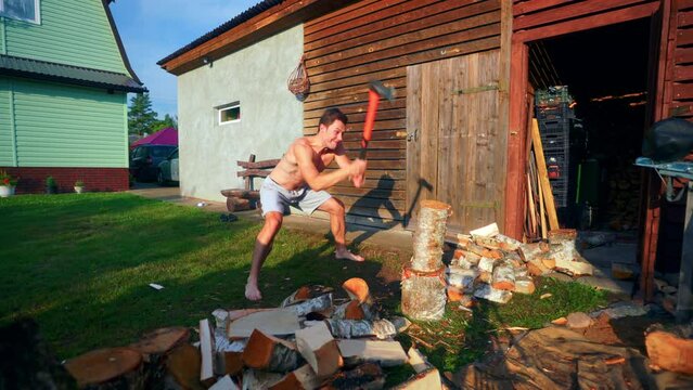A Strong Young Man Breaking A Log Using An Axe In Lithuania- Slow Motion
