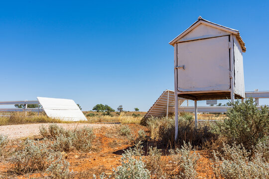 A mailbox and cattle grate against a blue sky in a rural setting