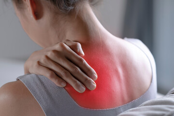 Asian woman has shoulder pain. Female holding painful shoulder with another hand. People with...