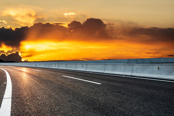 Asphalt road and sky clouds at sunrise. Road and sky background.
