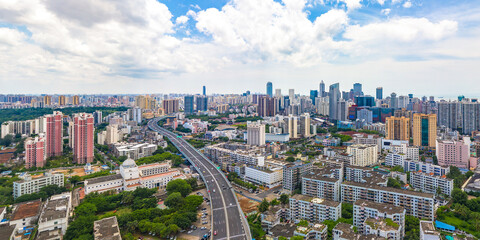 Fototapeta na wymiar Haikou Cityscape with Landmark Buildings and Urban Overpass during Sunny Daytime, Hainan Province, the Largest Free Trade Zone in China.