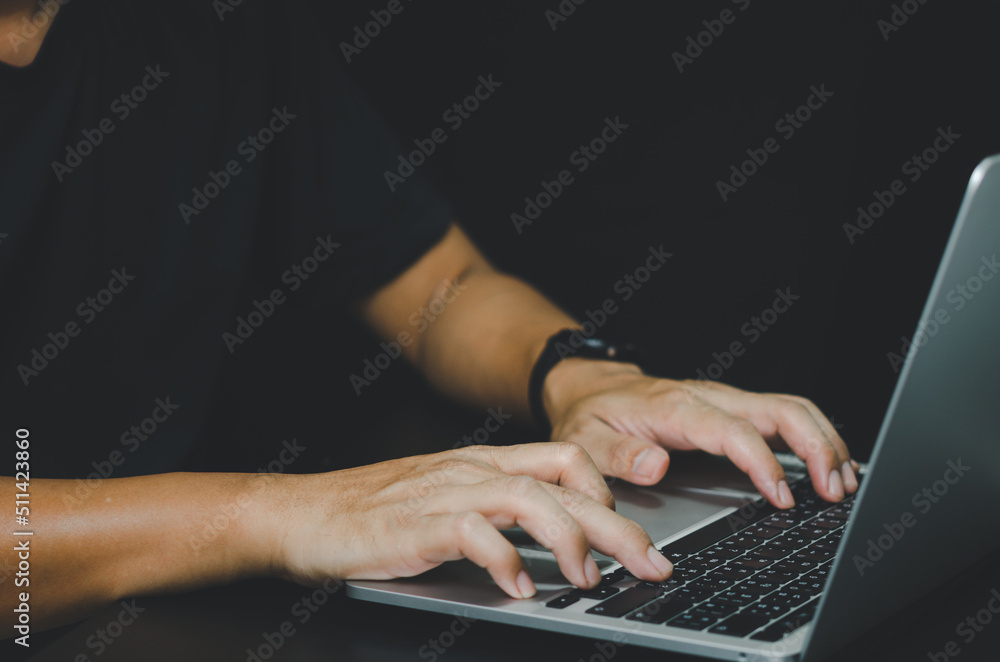 Poster person using in hand keyboard computer laptop on black background.