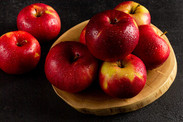 Fresh ripe red apples on a dark background, side view, vegetarian delicious product in a dark key