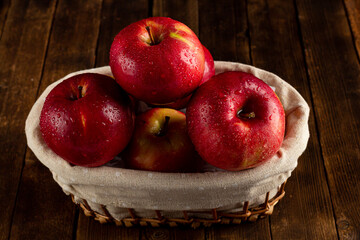 Fresh ripe red apples on a wooden table, side view, vegetarian delicious product in a rustic style