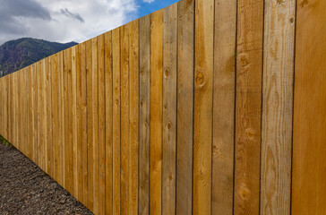 Nice wooden fence around house. New wooden fence in countryside.
