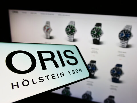 Stuttgart, Germany - 06-11-2022: Mobile phone with logo of Swiss watch manufacturing company Oris SA on screen in front of business website. Focus on center-left of phone display.