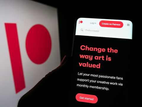 Stuttgart, Germany - 06-11-2022: Person holding cellphone with website of US membership platform company Patreon Inc. on screen in front of logo. Focus on center of phone display.