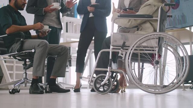 A disabled company employee is able to work happily with colleagues in the office.