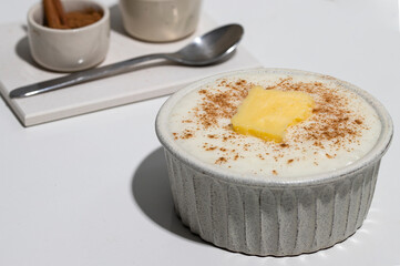 Close up of Risengrod bowl or  with butter and cinnamon on kitchen table .